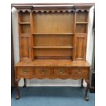 A mid-20th century walnut veneered dresser and rack, with three frieze drawers and raised on