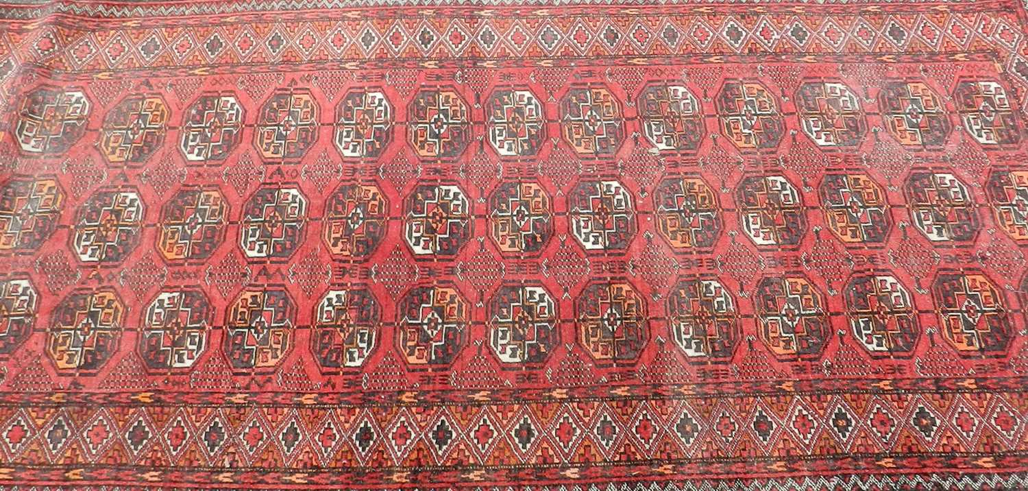 A Persian rug, first half 20th Century, with multiple geometric medallions on a red ground within