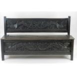 A 19th Century Eastern influence carved joined oak box settle, the back and front inset with