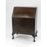An Edwardian mahogany bureau, the fall front above two short and two long drawers, raised on
