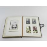 An Edwardian photograph album, leather bound, the leaves printed with flower sprays and gilt-edged