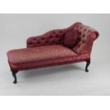 A reproduction Edwardian style chaise longue, with scroll form button back in raspberry brocade