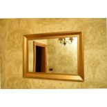 A contemporary giltwood wall mirror, the plain rectangular plate within a cavetto frame having an '
