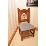A reproduction Gothic style standard chair, with a pierced and carved cusped arched panelled back