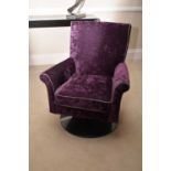A modern swivel upholstered armchair, with scroll arms, the fabric of dark plum chenille with