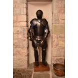 A reproduction suit of armour, set on a wood plinth stand, 172cm high (183 including stand), with