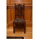 A pair of Edwardian oak and cane side chairs, the scroll top rails above caned splats, flanked by