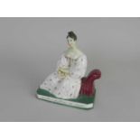A rare Staffordshire porcelain figure of Madame Maria Malibran circa 1836 modelled seated reading