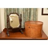 An Edwardian oak swing toilet mirror, with bevelled octagonal plate raised on barley-twist supports,
