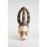 West African tribal Nigerian Igbo carved wood helmet mask, painted white and with ochre markings and