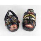 Two West African tribal Nigerian Ibibio painted masks, each grimacing with prominent cheekbones