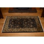 A set of three graduated Indo-Persian rugs, late 20th century, with formal scrolling foliage and