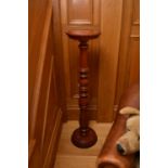 A reproduction mahogany torchere, the circular top above a turned baluster stem with foliate basal