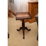 A reproduction George III style carved mahogany urn table, the square top with an open fretwork