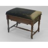 An Edwardian oak piano stool, with upholstered seat and aesthetic-movement influence aprons,