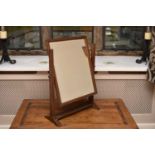 An Edwardian mahogany swing toilet mirror, with bevelled rectangular plate.63cm high, 43cm