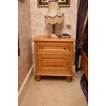 A pair of recent Clive Christian light oak bedside cabinets, with a panelled drawer above a panelled
