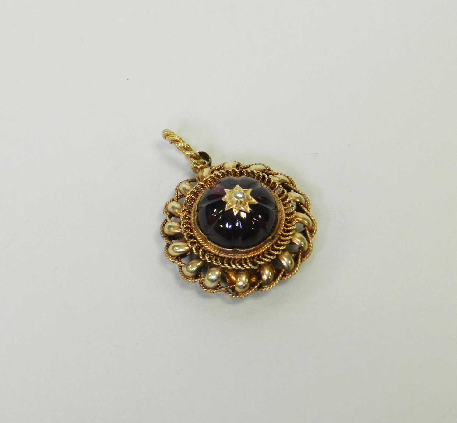 A Victorian style garnet and diamond locket pendant