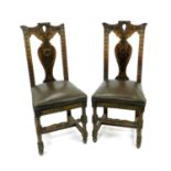 A set of four Edwardian carved oak high-back dining or side chairs, with vase splats and foliate top