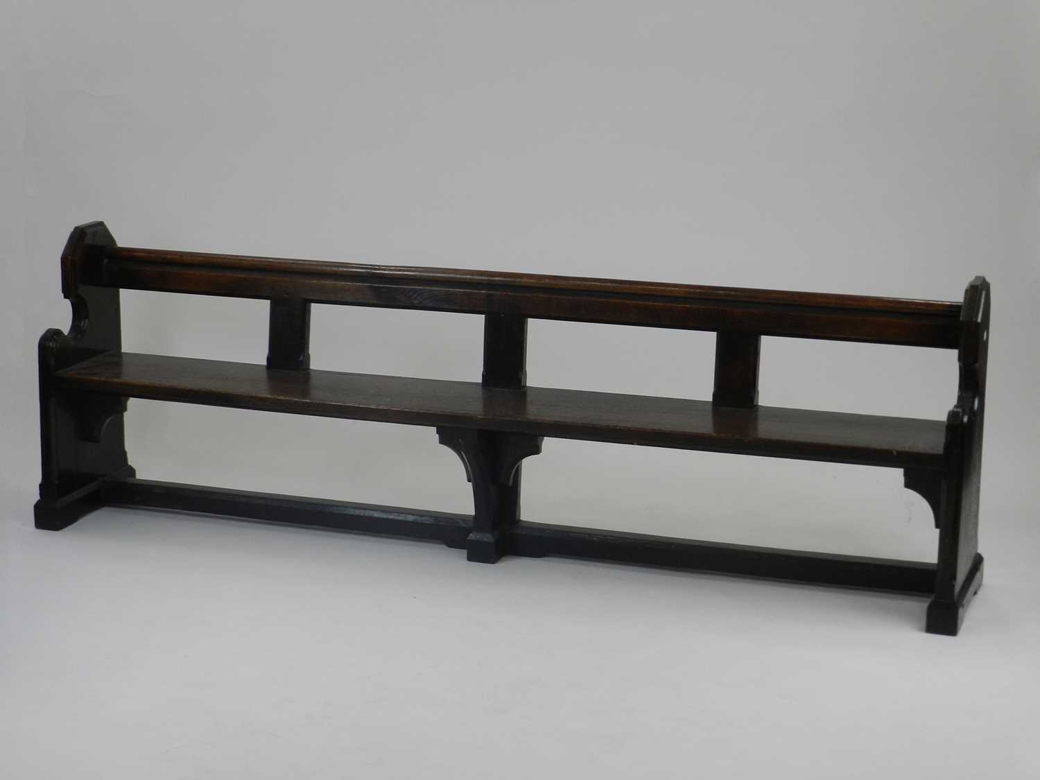 A 19th century joined oak pew, of plain bench type with shaped sides and moulded top rail, 214cm