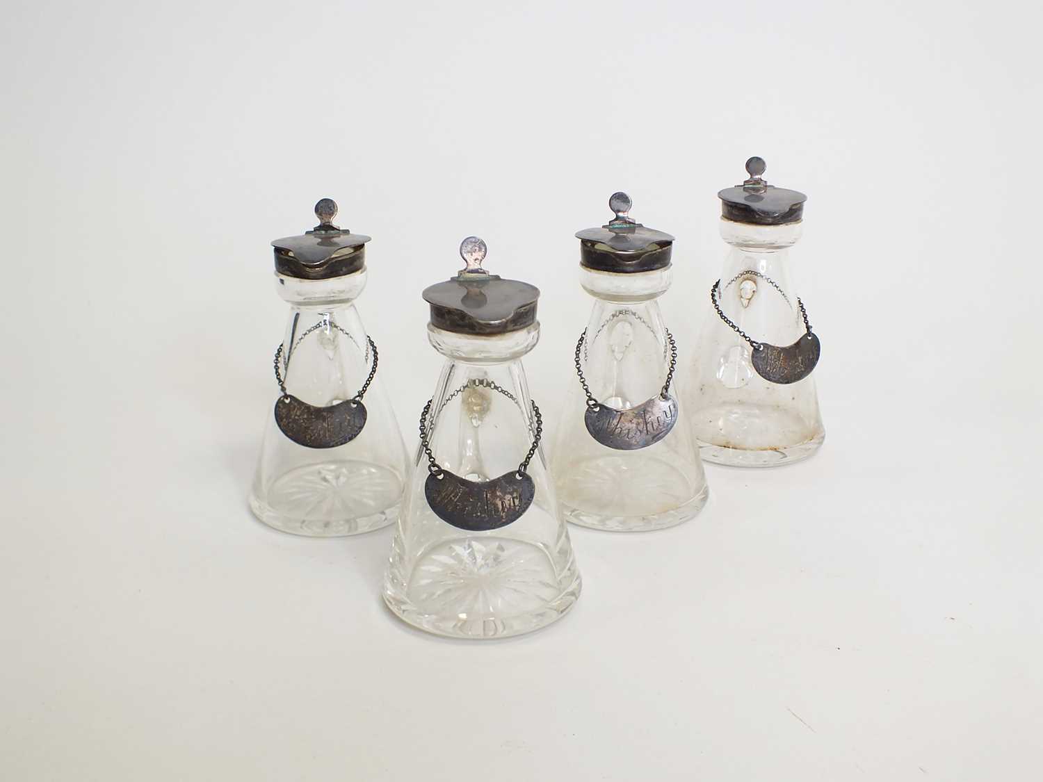 A set of four silver topped whiskey noggins and labels