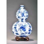 A Chinese blue and white gourd vase and wood stand