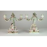 A pair of German porcelain figural sweetmeat candelabra