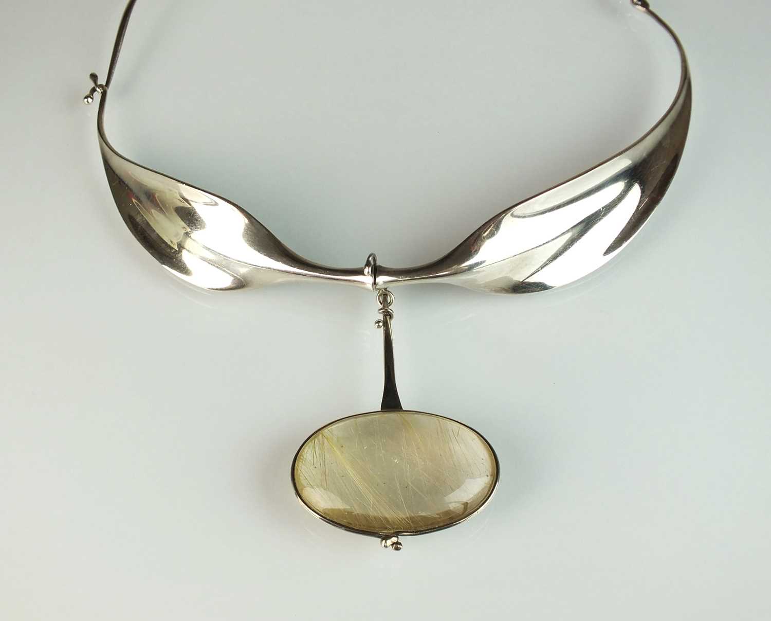 A Georg Jensen silver neck ring and rutilated quartz pendant designed by Vivianna Torun Bulow-Hube