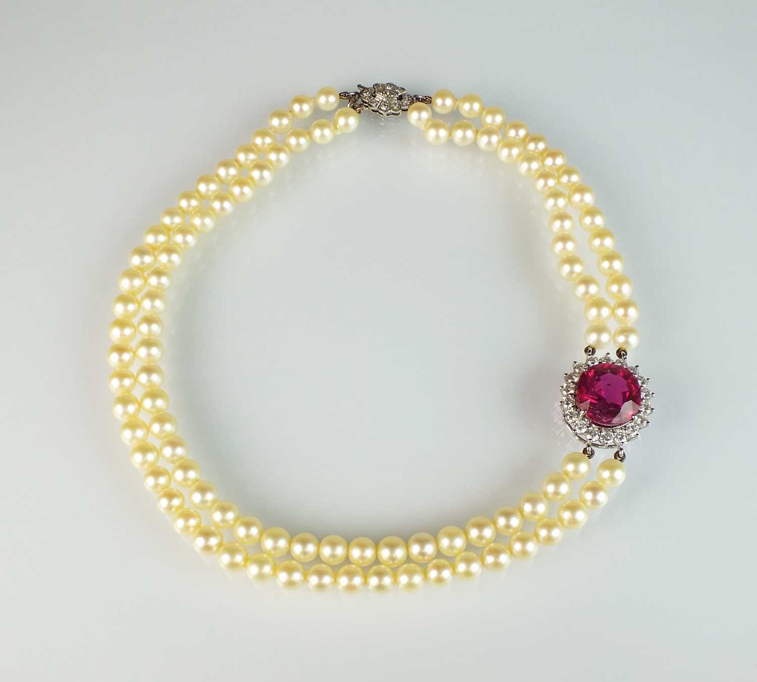 A pink tourmaline and diamond cluster on two strand cultured pearl necklace