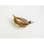 A 9ct gold cabochon sapphire set leaf brooch