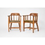 A pair of Arts and Crafts style oak elbow chairs
