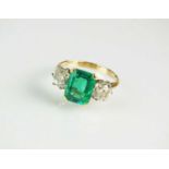 A three stone emerald and diamond ring