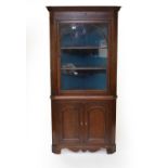 A George III oak glazed standing corner cabinet