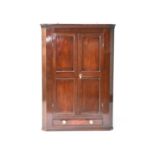 An early-mid 19th century mahogany, hanging corner cupboard