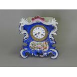 A French Rococo style porcelain mantel clock, by 'Leroy Paris' and another (2)