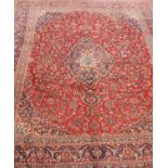 A large red-ground Persian Kashan carpet