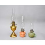 A brass oil lamp and two glass oil lamps