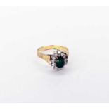 An emerald and diamond cluster ring