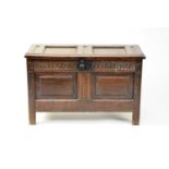 A small 17th century oak coffer with a twin panelled top