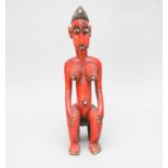 A West African Bobo red painted seated female figure