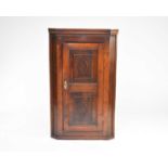 A George III oak hanging corner cupboard