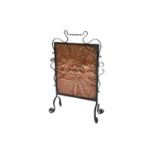 A wrought iron and copper fire screen