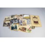 A collection of Edwardian postcards in two albums, together with one scrapbook and some further