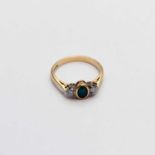 An 18ct gold three stone emerald and diamond ring