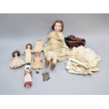 A German porcelain-headed doll with other dolls and accessories