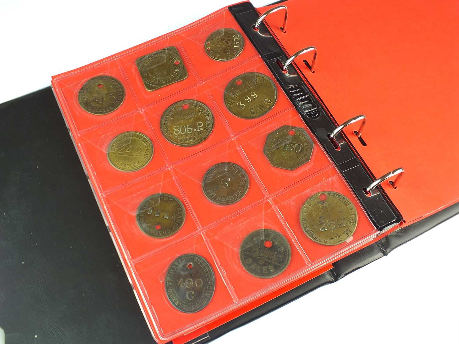 An album containing fifty-one brass and white metal colliery and associated tokens