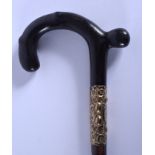 A 19TH CENTURY CONTINENTAL CARVED RHINOCEROS HORN WALKING CANE with gold mounts. 88 cm long.