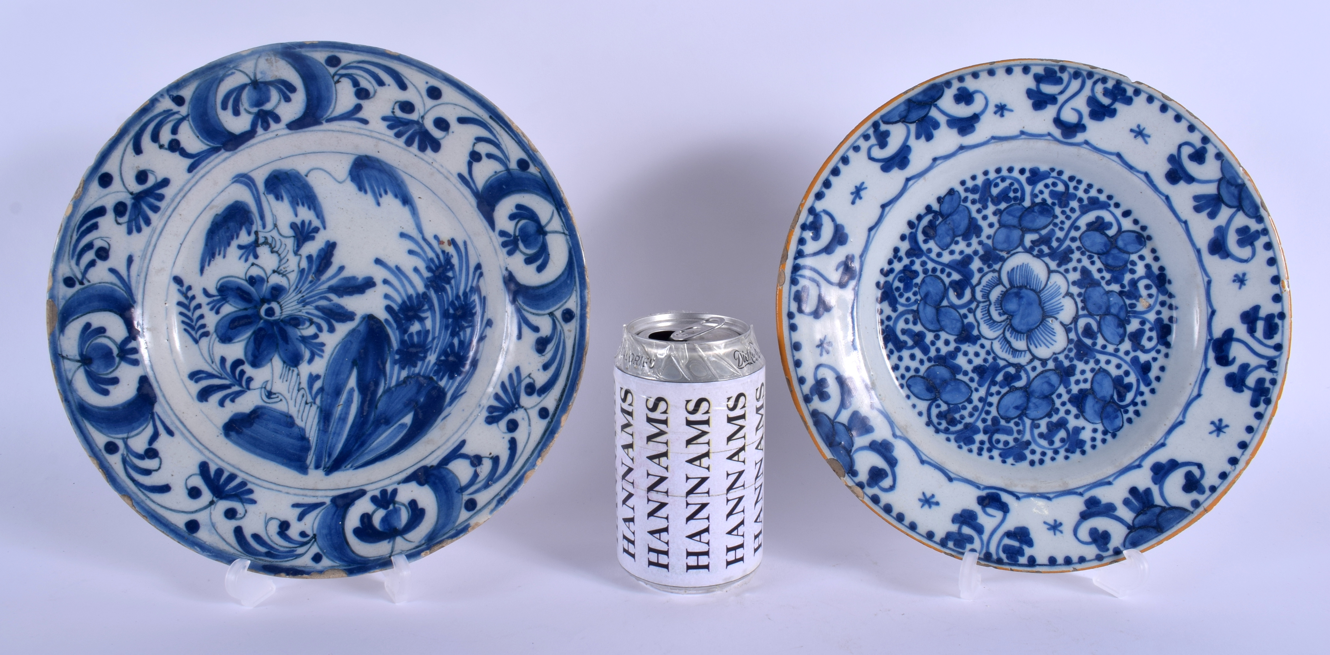 TWO 18TH CENTURY DUTCH DELFT BLUE AND WHITE POTTERY PLATES painted with flowers and motifs. 22 cm di