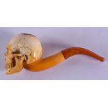 A 19TH CENTURY CARVED MEERSCHAUM AND AMBER PIPE formed as a skull. 15 cm wide.