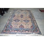 A LARGE PERSIAN MIDDLE EASTERN BLUE AND BEIGE GROUND CARPET decorated with motifs and foliage, by re